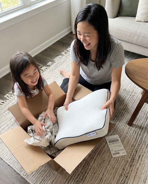 A mother and her daughter opening the Little Otter parcel together on the living room floor